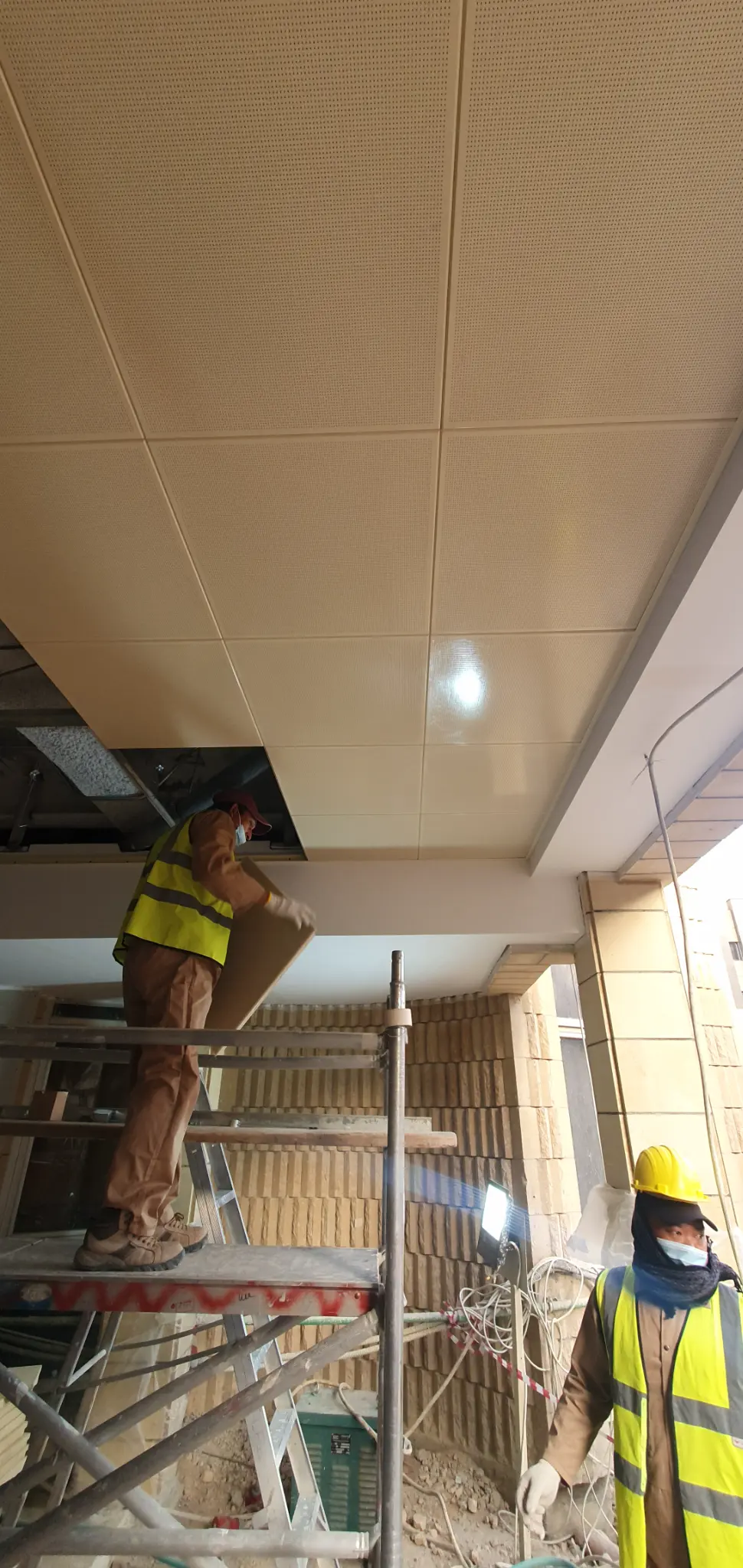 Workers installing suspended ceiling panels